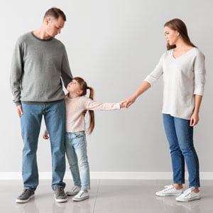 A child holding hands with parents, symbolizing child custody. - Law Office of Jordana N. Better