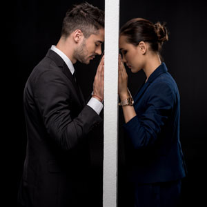 A couple exchanges intense gazes at a doorway, possibly reflecting the emotional turmoil of a divorce - Law Office of Jordana N. Better